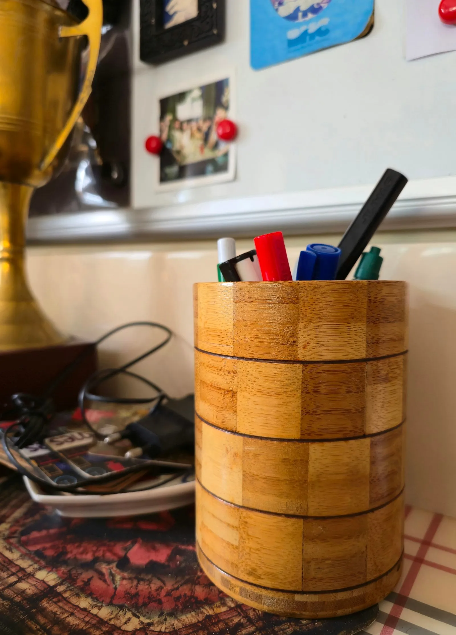 A wooden pen holder filled with pens