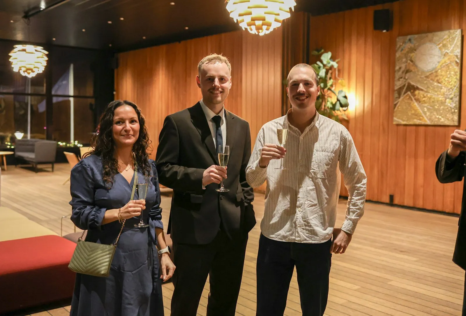Three people holding champagne glasses