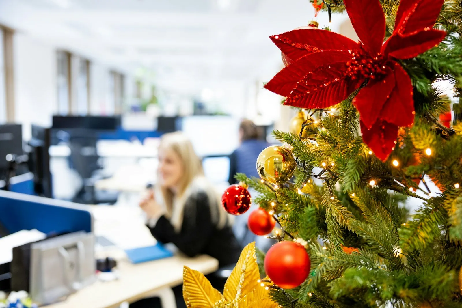 A decorated holiday tree in an office cubicle