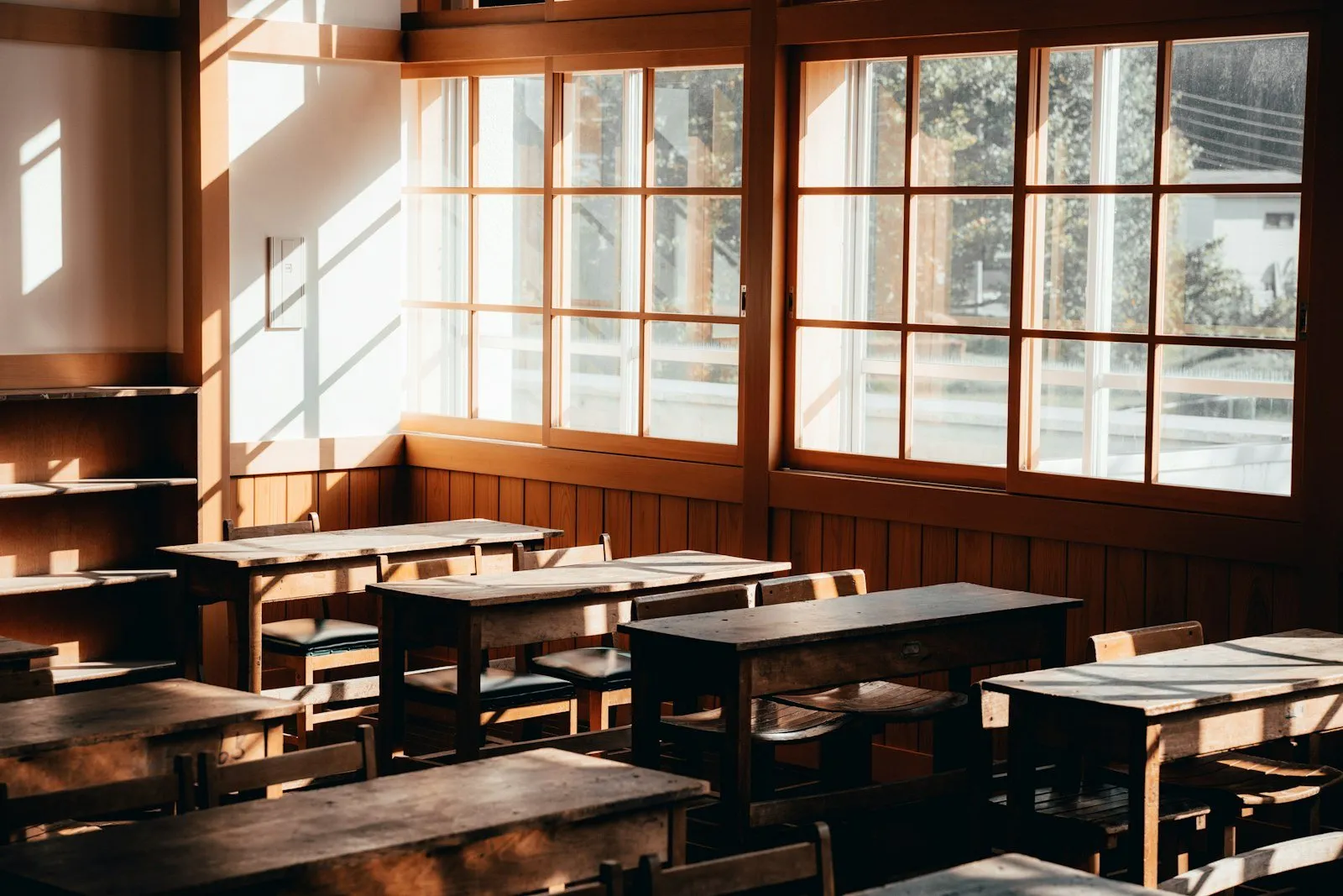 Empty classroom with wooden desks and windows