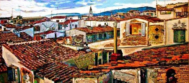 A wide view across the terracotta rooftops of an old Italian town under a clear sky