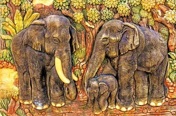 A family of elephants with a calf at their feet, standing among bright jungle foliage in painted relief