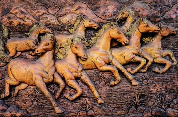 A herd of horses gallops along a riverbank beneath rolling hills, in warm terracotta relief