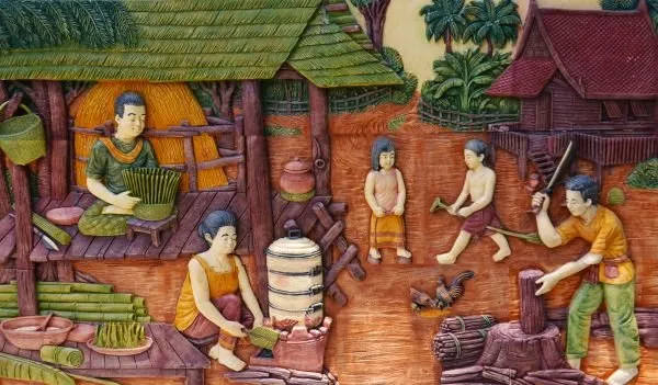 A lively village courtyard of cooks, children and farm work beneath thatched huts, in painted relief