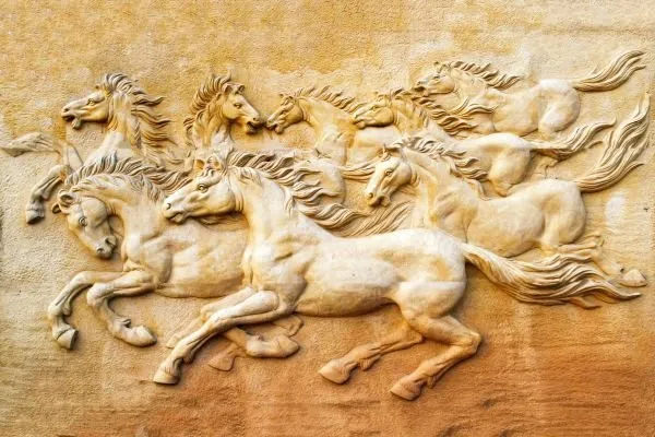 A herd of ivory horses gallops with flowing manes across a soft cream-and-ochre relief