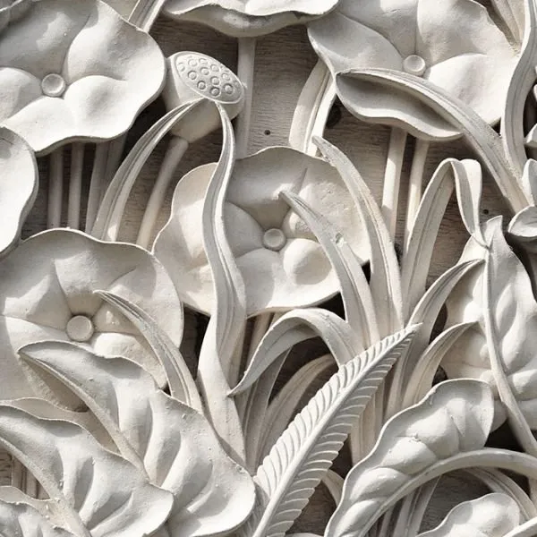 Lotus seed pods, curled leaves and slender stems in a close-up white sculpted relief