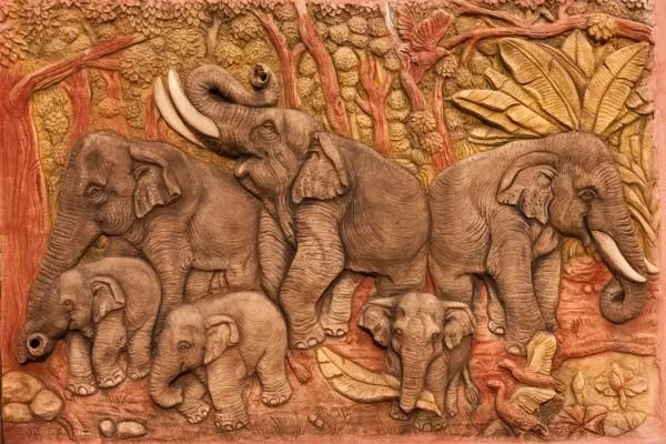 A herd of elephants with playful calves moves through the jungle in rich terracotta-red relief