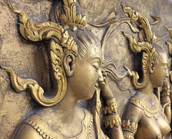 A row of crowned musicians in profile, the nearest playing a flute, in warm antique gold