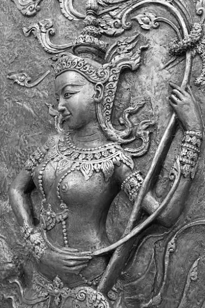A crowned celestial figure holding a curved bow, framed by flame-like ornaments in silver-grey