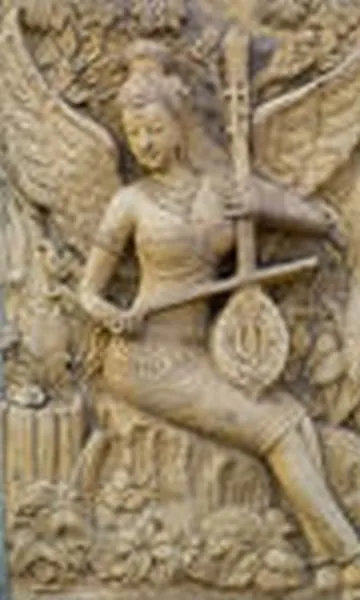 A winged celestial musician plays a long-necked lute, carved in pale sandstone