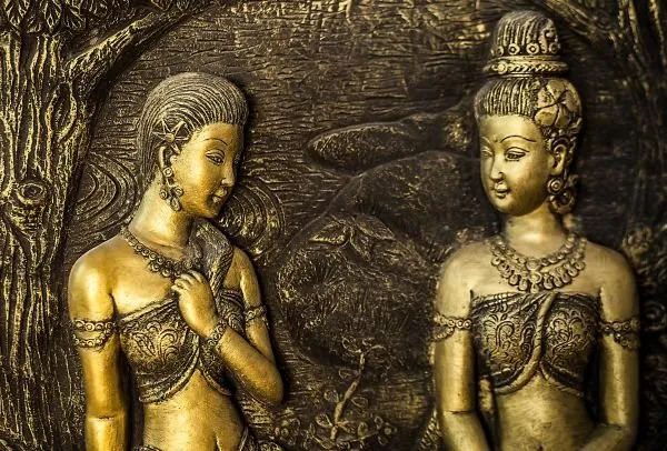 Two golden maidens with jewelled collars stand side by side against a dark forest relief