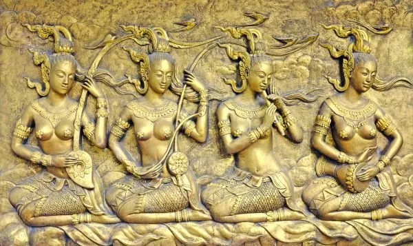 Four seated celestial musicians play lutes and flutes, in a glowing gold relief