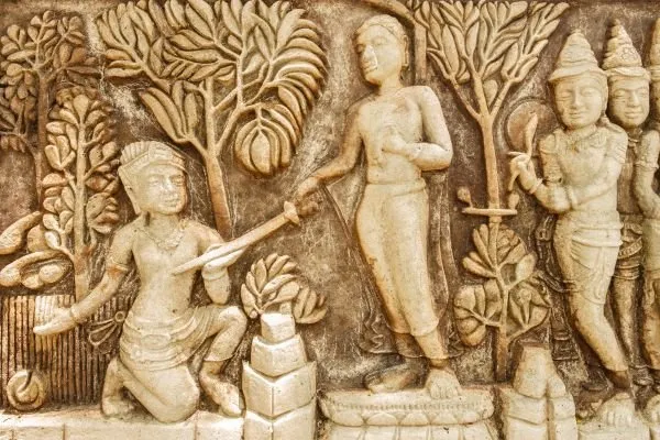 Robed figures gather beneath fruiting trees with offerings, in a weathered stone relief