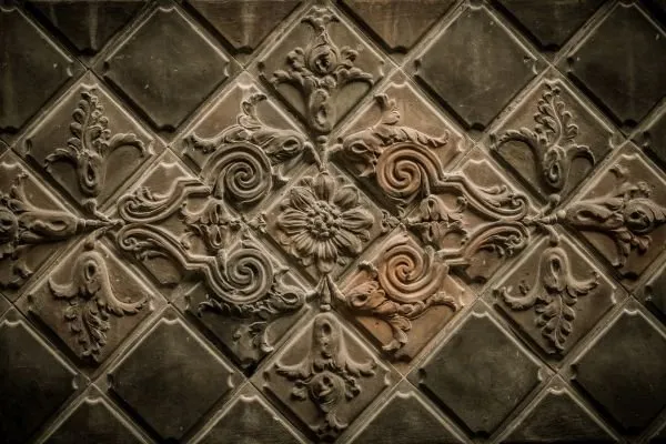 Diamond-set rosettes and scrolling ornaments in an antique bronze lattice relief