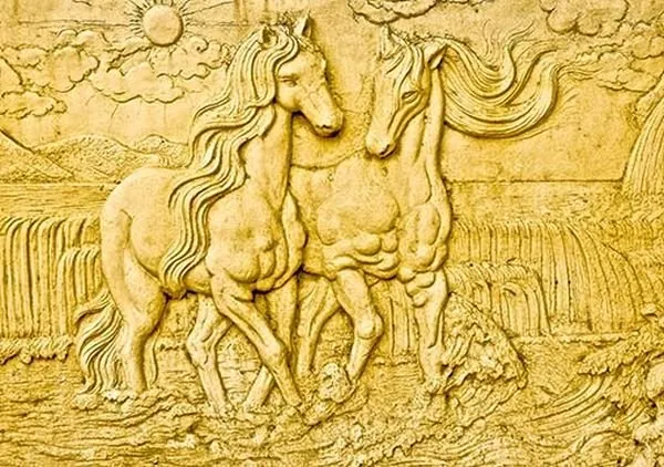 Two horses stand together beneath a rising sun and a waterfall, in gleaming gold relief