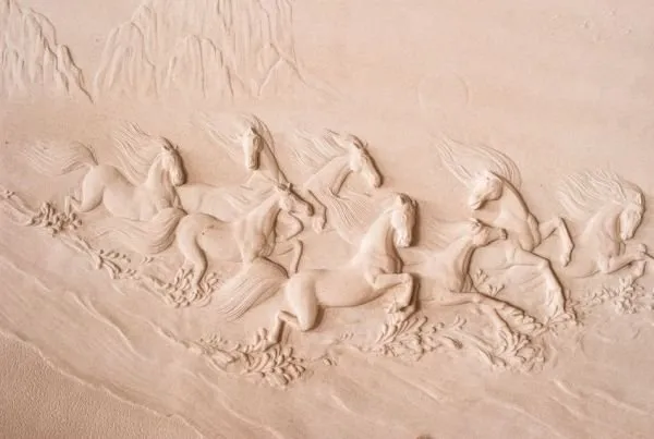 A faint herd of horses gallops across a blush-pink, sand-textured relief