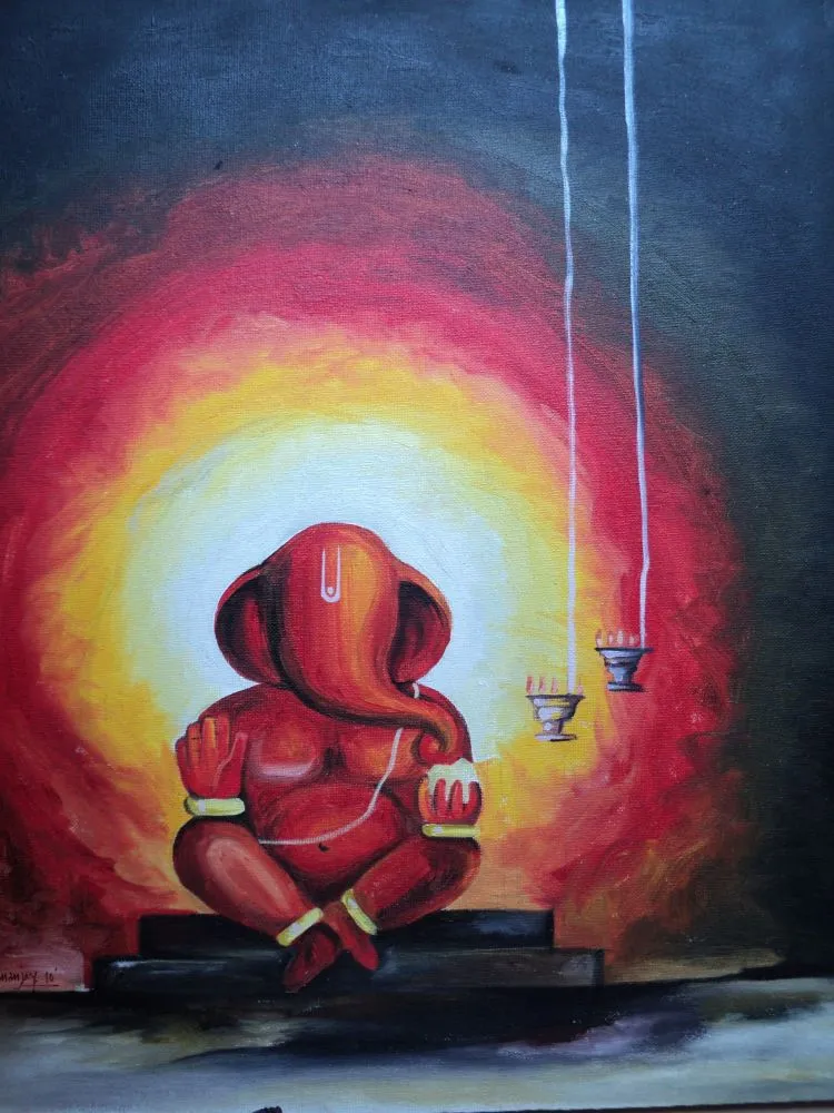 A small red Ganesha seated within a luminous red and yellow aura on a dark wall, with hanging lamps