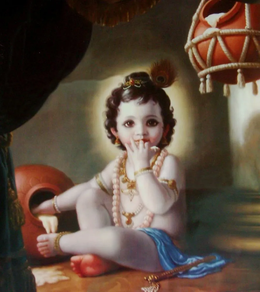 A curly-haired baby Krishna sits among clay butter pots with a finger at his lips, softly lit against a dark curtain