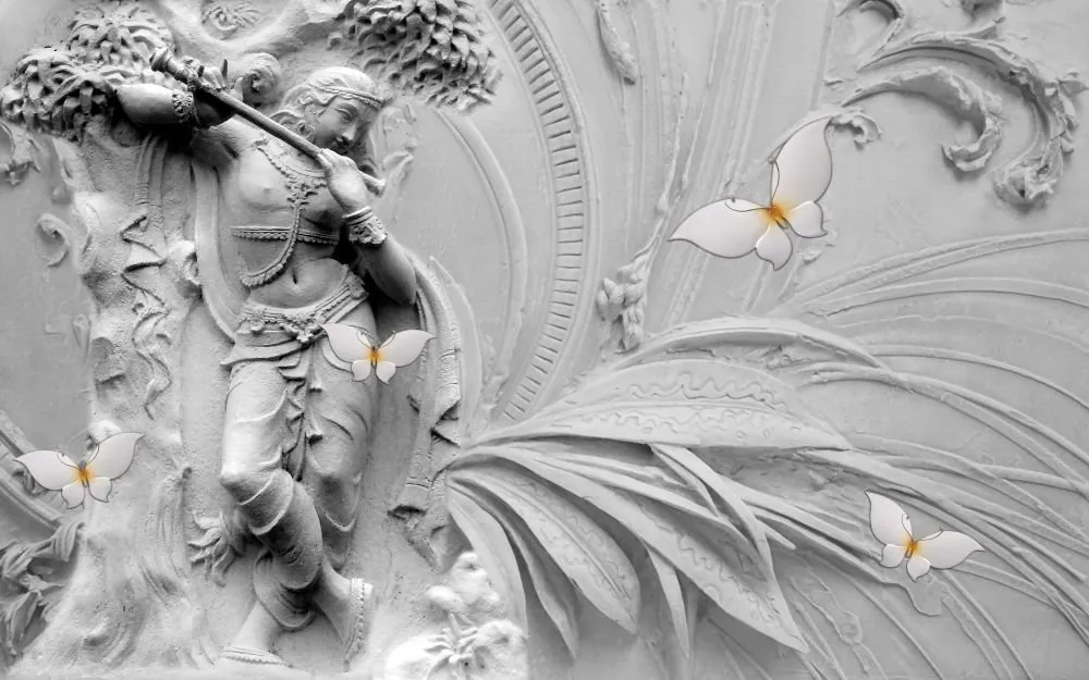 A white sculpted relief of Krishna playing the flute beneath a tree, with leaves and butterflies in pale grey