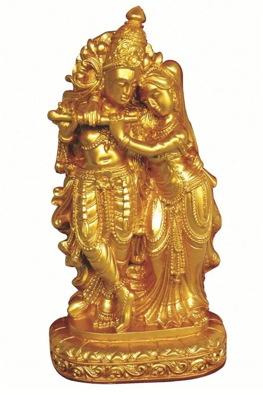 A photograph of a gleaming gold Radha Krishna statue standing on an ornate base