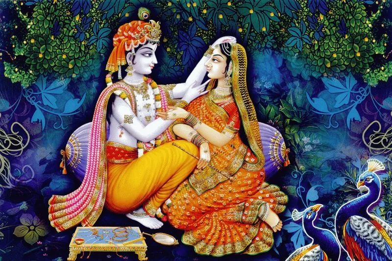 Krishna tenderly adorning Radha as they sit together, with peacocks and dark blue foliage around them