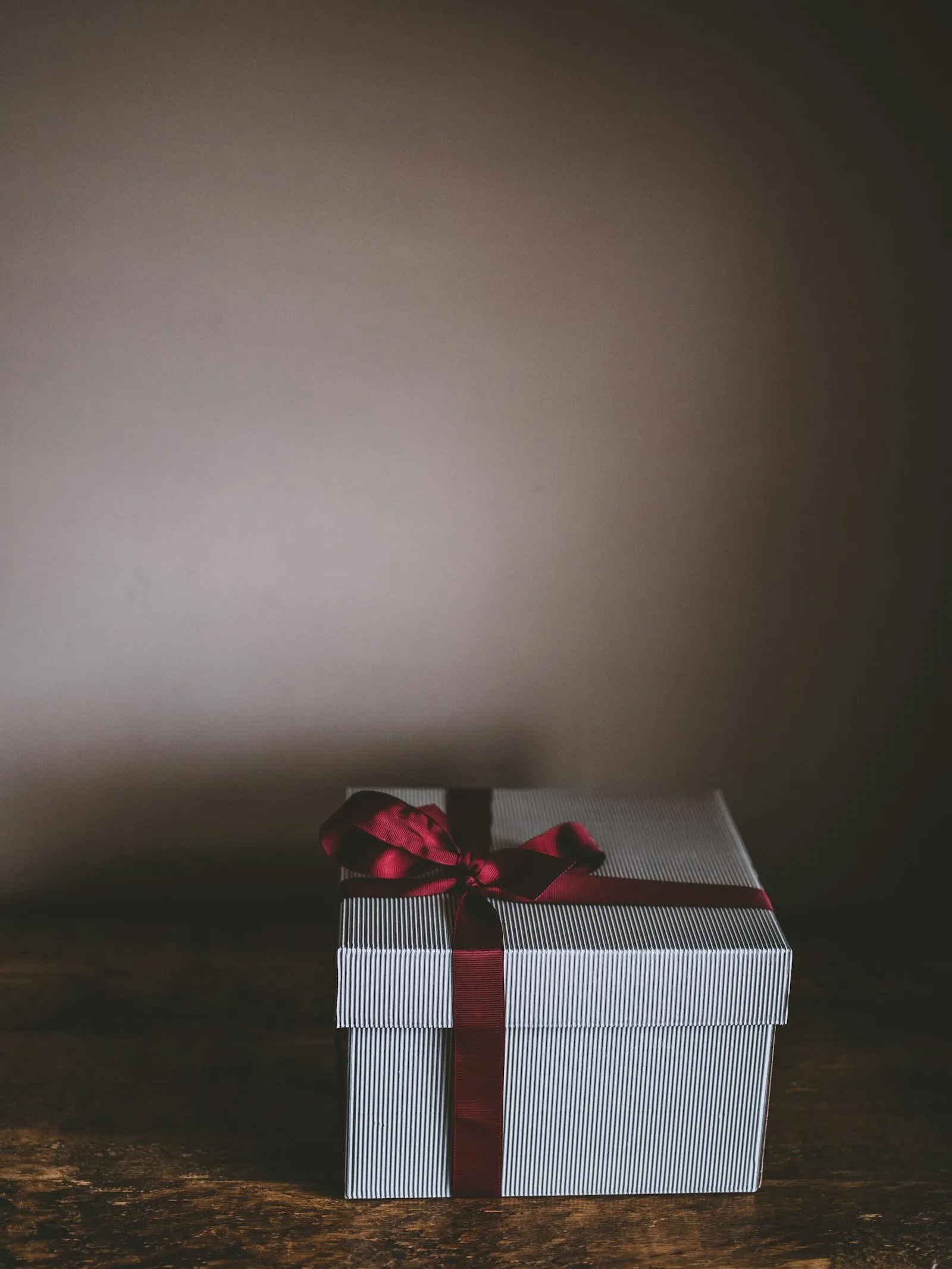 A white gift box with a red ribbon
