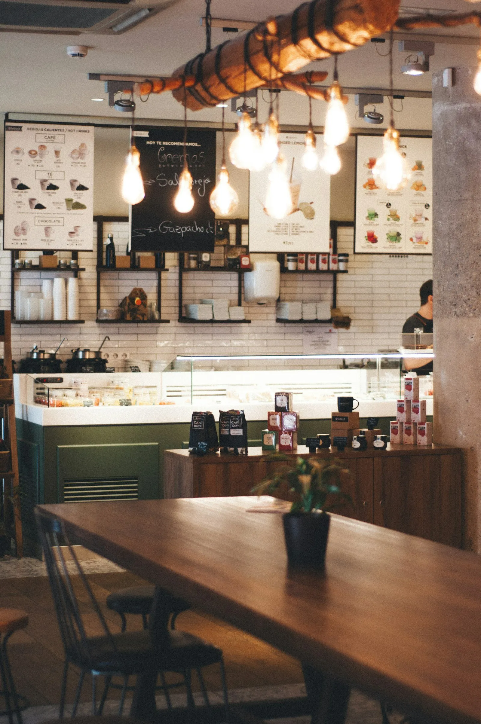 A cafe interior with hanging bulb lights and tables